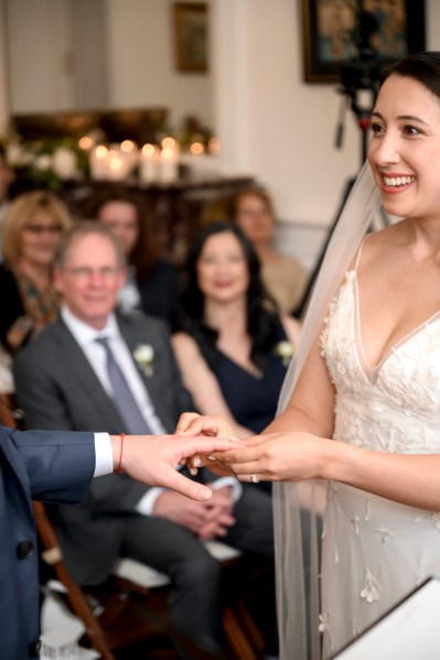 Close up of couple exchanging wedding bands/rings bride smiles